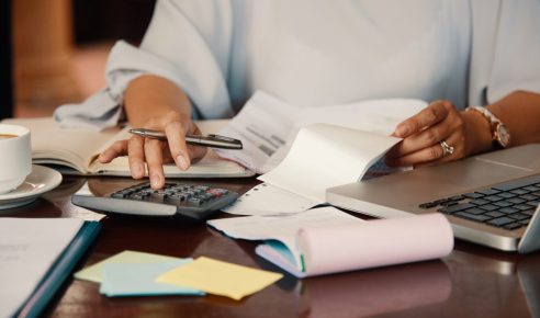 Hands of female entrepreneur working with bills and documents