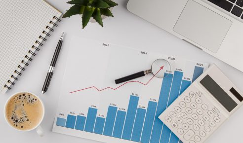 vista-superior-da-mesa-do-escritorio-com-grafico-de-crescimento-e-calculadora